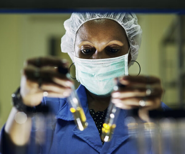 Science and research, woman working as chemist looking at test tube in laboratory